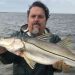 A man catched a silverfish from the sea.