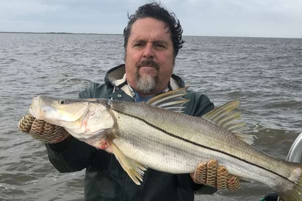 A man catched a silverfish from the sea.