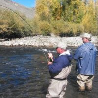 Image showing two elder fishermen fishing on the river bank