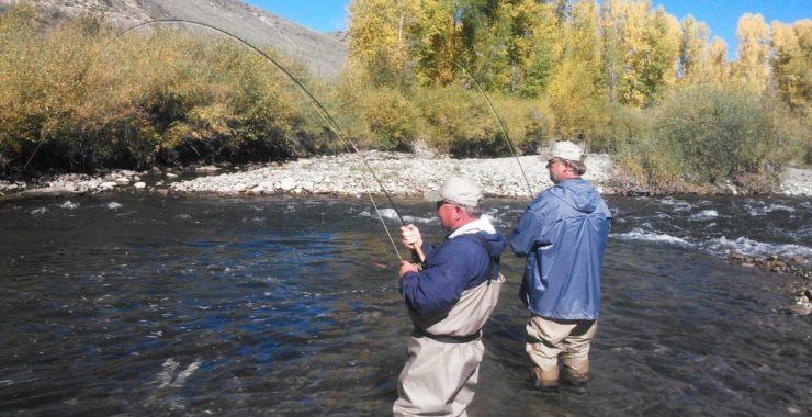 Image showing two elder fishermen fishing on the river bank