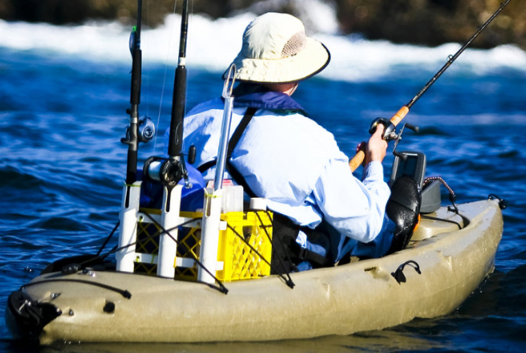 Solitary FIsherman In White Kayak.