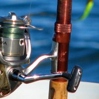 A Close-up View Of Fishing Rod & Gear In A Sea Background.