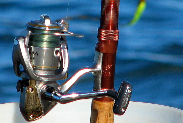 A Close-up View Of Fishing Rod & Gear In A Sea Background.