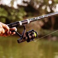 A Man Holding Spinning Rod In His Hand.