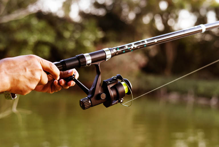 A Man Holding Spinning Rod In His Hand.