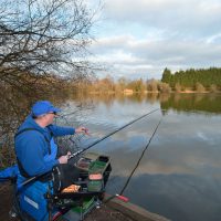 A Man Polefishing In A Lake.