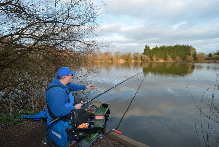 A Man Polefishing In A Lake.