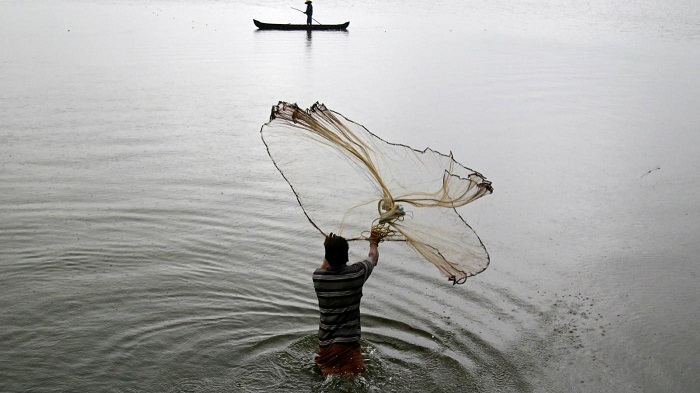 A Man Throwing The Net Over The Water.